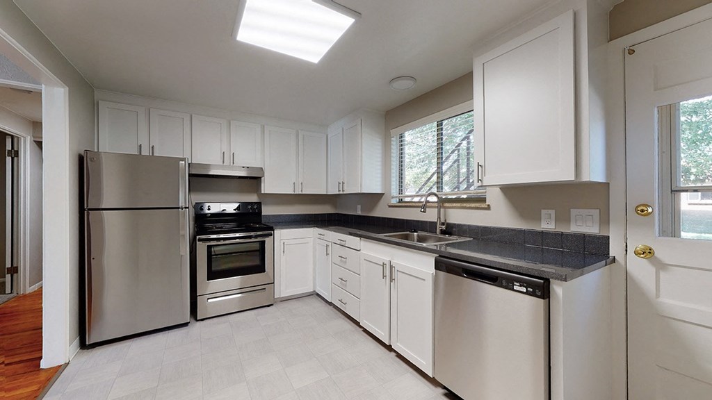 A modern kitchen with stainless steel appliances and white cabinets.
