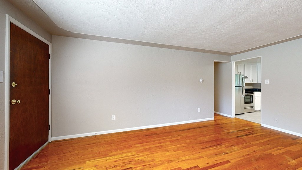 A room with wooden floors and a brown door.