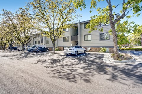 A car is parked in a parking lot in front of a building.
