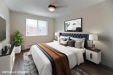 A bedroom with a large bed and a ceiling fan.