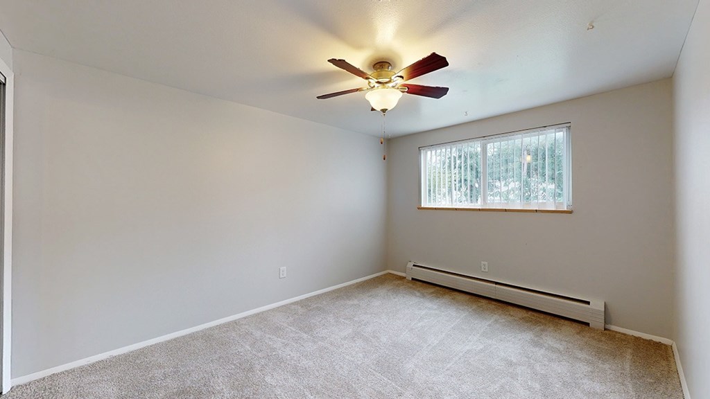 Bedroom with carpeting, a ceiling fan and a window with blinds.
