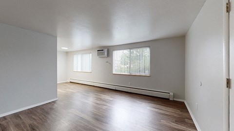 Living area with wooden floors and white walls.