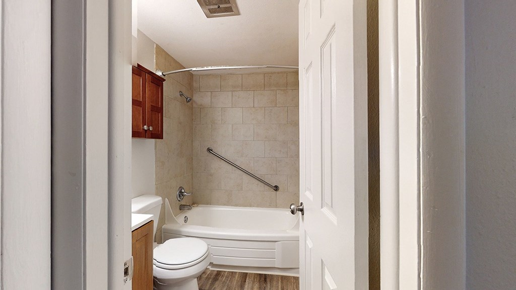 A white bathroom with a toilet, tub, and shower.