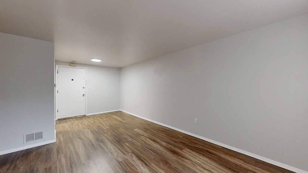 A room with a wooden floor and white walls.