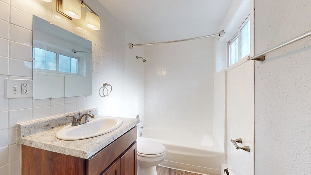 A bathroom with a white tub and a white sink.