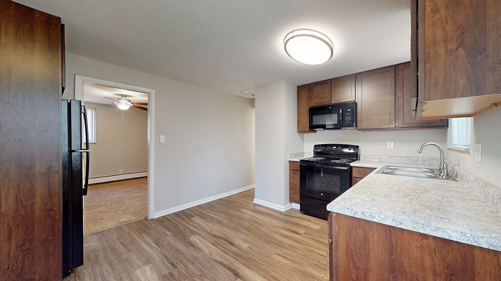 A kitchen with a black oven and microwave built into the cabinetry.