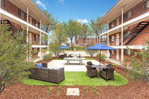 A courtyard with a table and chairs surrounded by buildings.