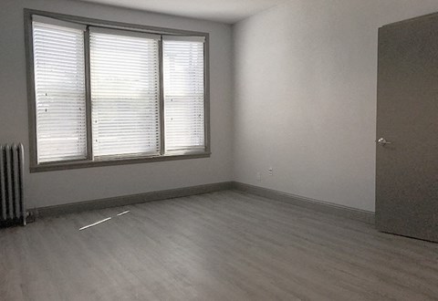 A room with a window and a radiator on the wall.
