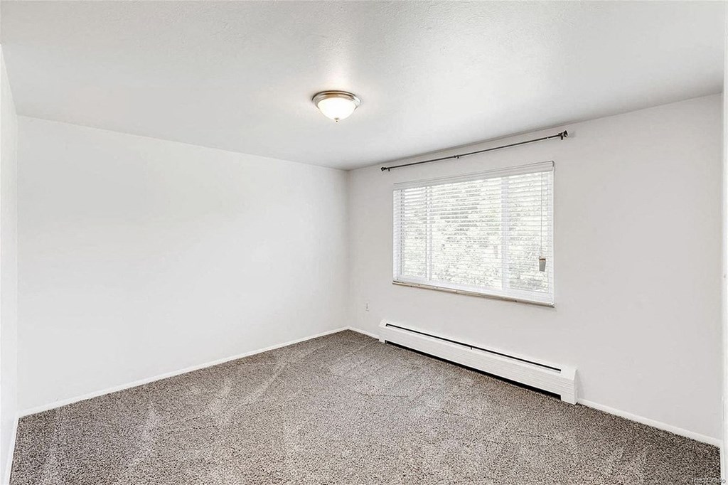 A room with a window and a radiator on the wall.