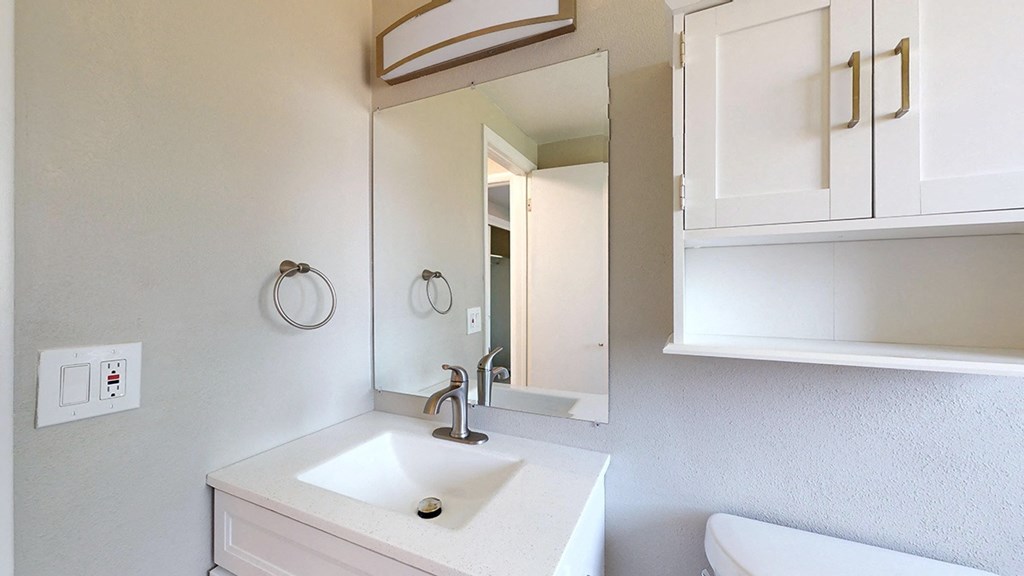 A white sink with a mirror above it.