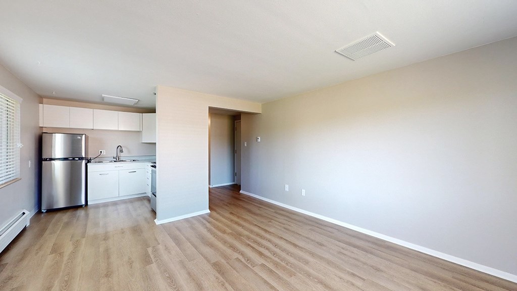 A kitchen with white cabinets and a stainless steel refrigerator.