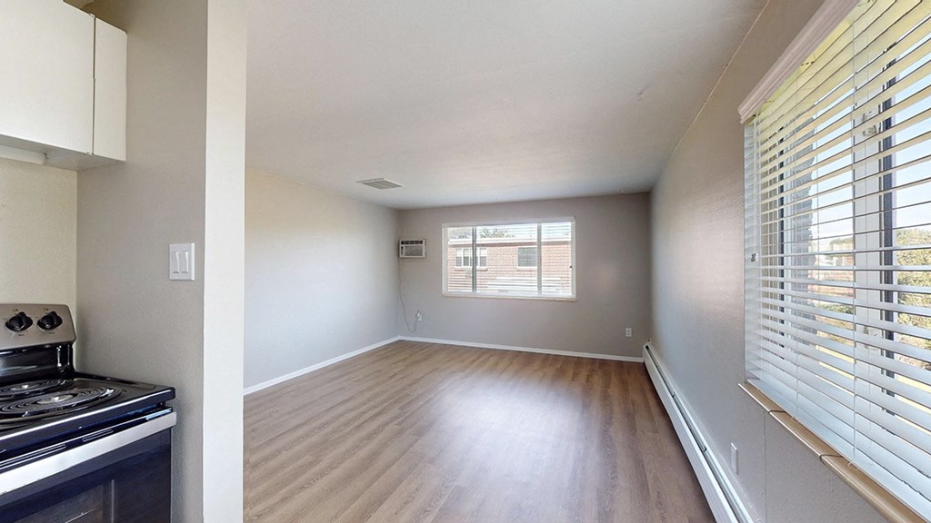 A kitchen with a stove and a window with blinds.