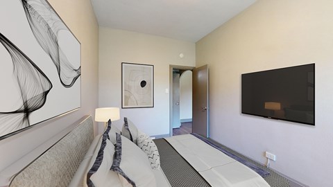 A modern bedroom with a bed and a painting on the wall.
