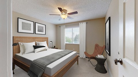 A bedroom with a bed, chair, and pictures on the wall.