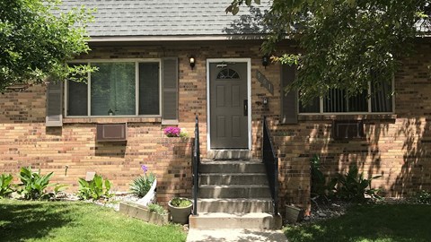 A house with a grey front door and a small garden.