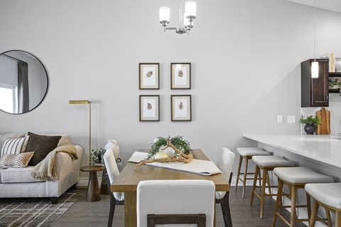A modern dining room with a wooden table and chairs.