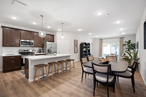 A modern kitchen with a dining table and chairs.