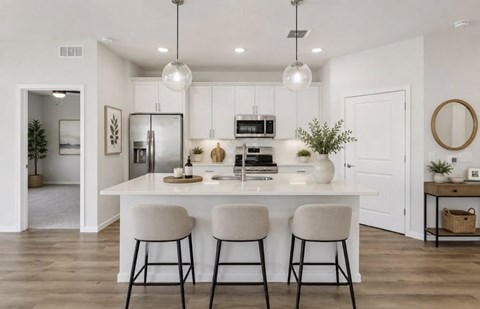 A modern kitchen with white cabinets and a central island.