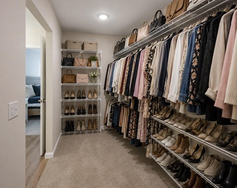 A walk in closet with a variety of shoes and clothes.