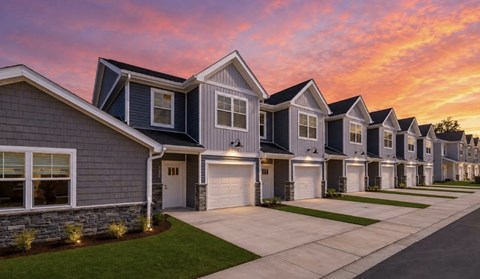 A row of houses with garages and driveways.