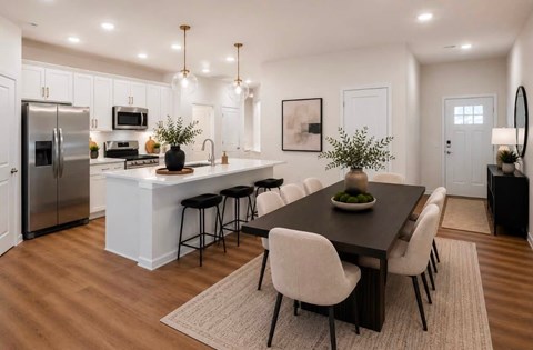 A modern kitchen with a dining table and chairs.