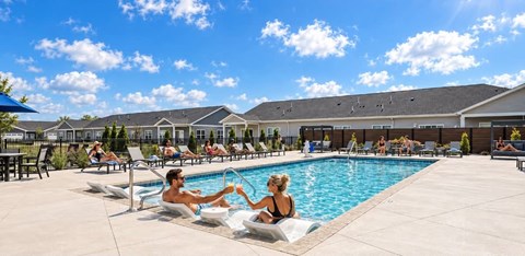 A man and a woman are sitting by a pool.