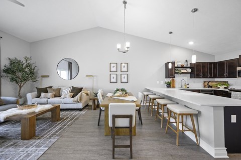 A modern kitchen and living room with a dining table and chairs.