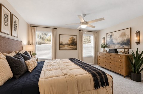 A bedroom with a large bed and a ceiling fan.