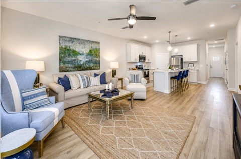 A living room with a sofa, chairs, and a rug.