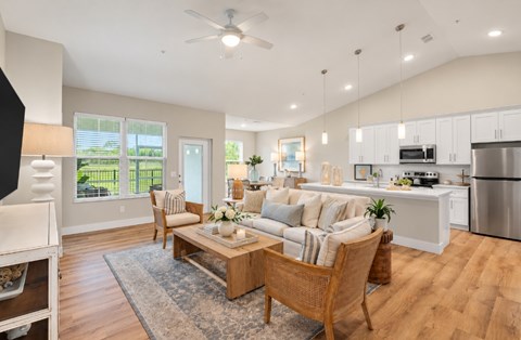 A modern living room with a kitchen in the background.