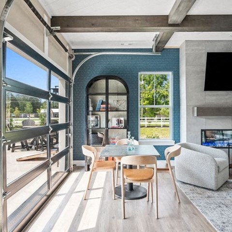 A modern living room with a fireplace and a dining table with chairs.