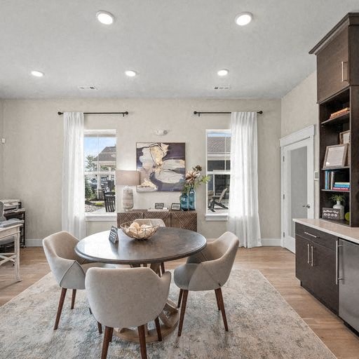 A modern dining room with a round table and chairs.
