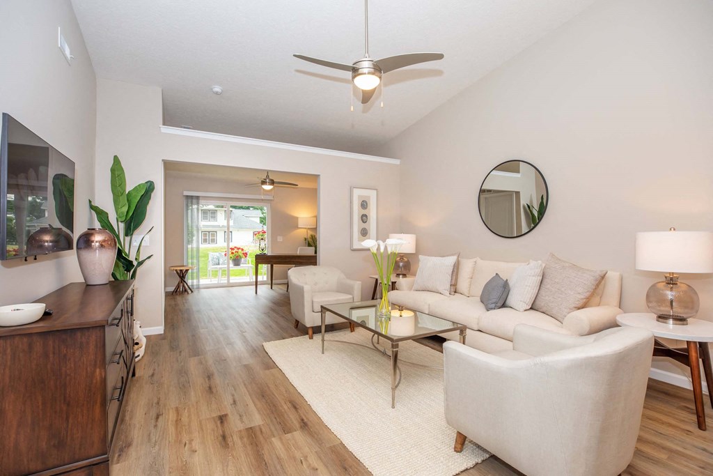 A modern living room with a white sofa and a wooden floor.