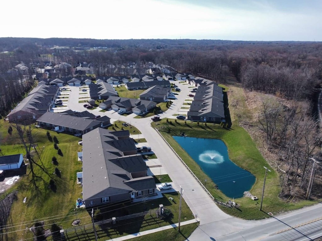 A bird's eye view of a residential area with houses and a swimming pool.