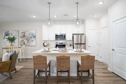 A modern kitchen with a dining table set for four.