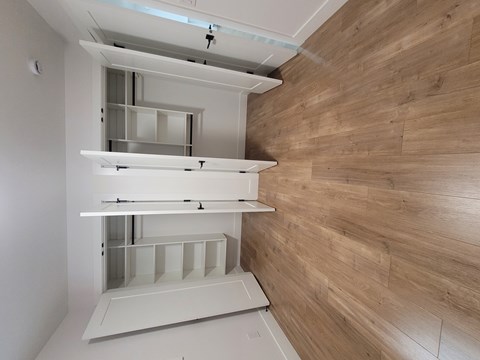 A kitchen with a white cabinet and a wooden wall.