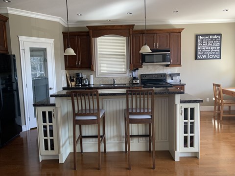 A kitchen with wooden cabinets and a black fridge.