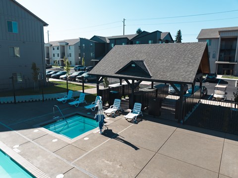 A pool with a pavilion and chairs in front of apartment buildings.at Eastpark Apartment Homes, Oregon, 97301