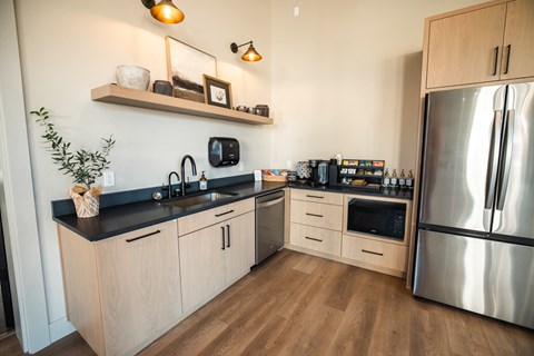 A kitchen with wooden cabinets and a stainless steel refrigerator.