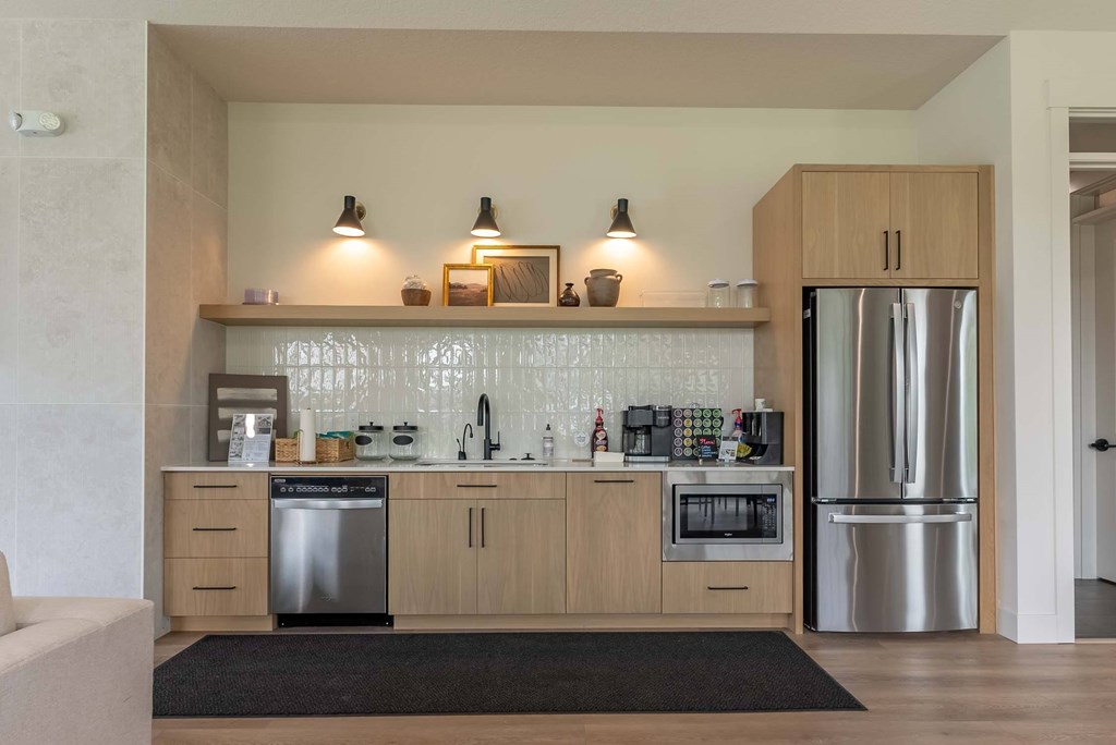A modern kitchen with wooden cabinets and stainless steel appliances. A modern kitchen with wooden cabinets and stainless steel appliances at Marcola Apartment Homes, Forest Grove