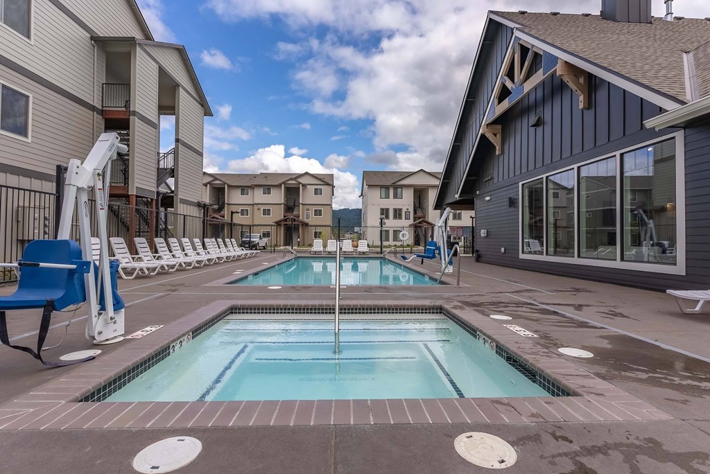 A swimming pool in a residential area with a blue chair. A swimming pool in a residential area with a blue chair at Marcola Apartment Homes, Forest Grove, 97477