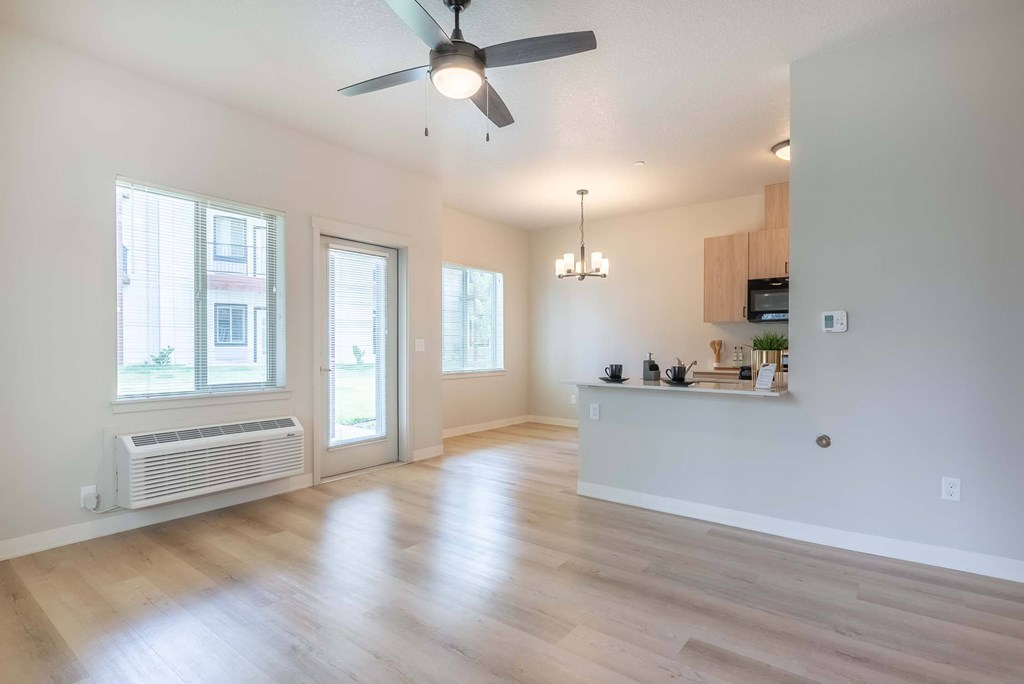 A spacious room with a ceiling fan and wooden flooring. A spacious room with a ceiling fan and wooden flooring at Marcola Apartment Homes, Forest Grove, OR