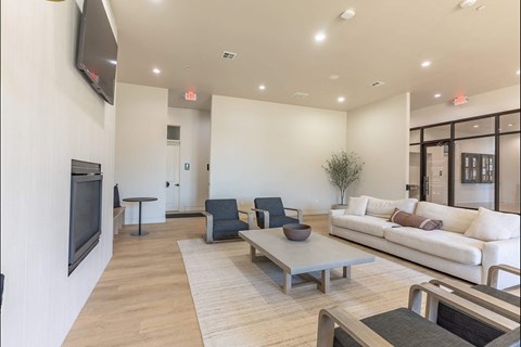 A living room with a white couch, a black television, and a wooden coffee table at Northplace Apartment Homes, Oregon
