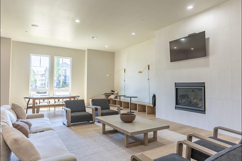 A living room with a grey couch, a wooden coffee table, and a television mounted on the wall at Northplace Apartment Homes, Oregon, 97305