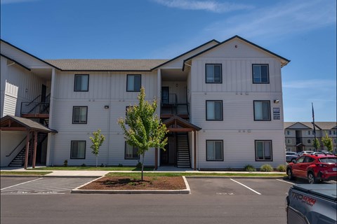 A white apartment building with a red car parked in front at Northplace Apartment Homes, Salem, 97305