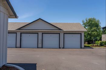 A building with a brown roof and white garage doors.