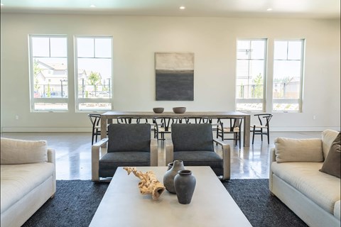 A living room with a white couch, a white coffee table, and a large painting on the wall.