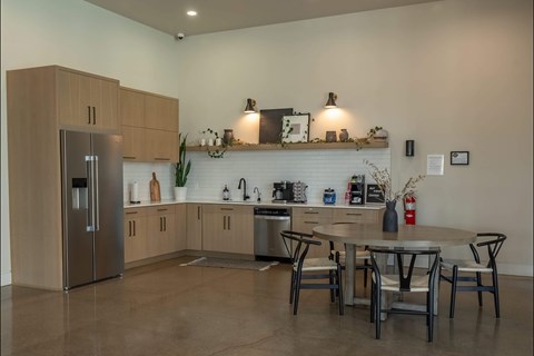 A modern kitchen with a refrigerator, sink, and dining table at Northplace Apartment Homes, Salem