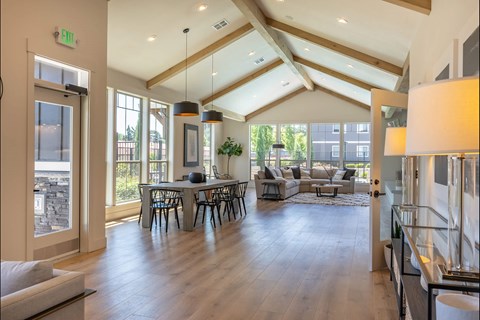 A spacious living room with a dining table and chairs.