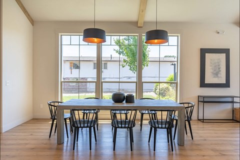 A dining room with a table and chairs.